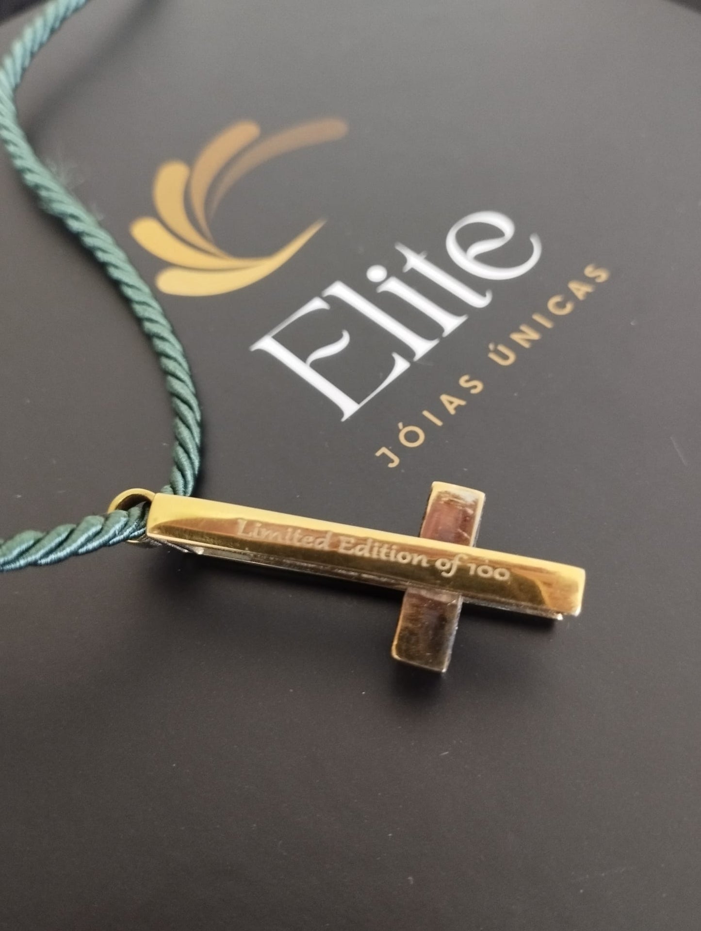 colar dos sorrisos exclusivo ELITE com pingente cruz dourada gravada Limited Edition of 100 e cordão verde trançado