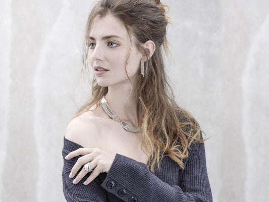 Modelo usa colar trapézio feminino em prata polida com brincos e anéis, look elegante Carmo Joalheiros