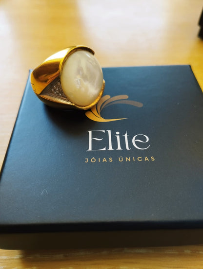 anel madrepérola feminino ELITE dourado com pedra oval e detalhes em zircônia sobre estojo preto