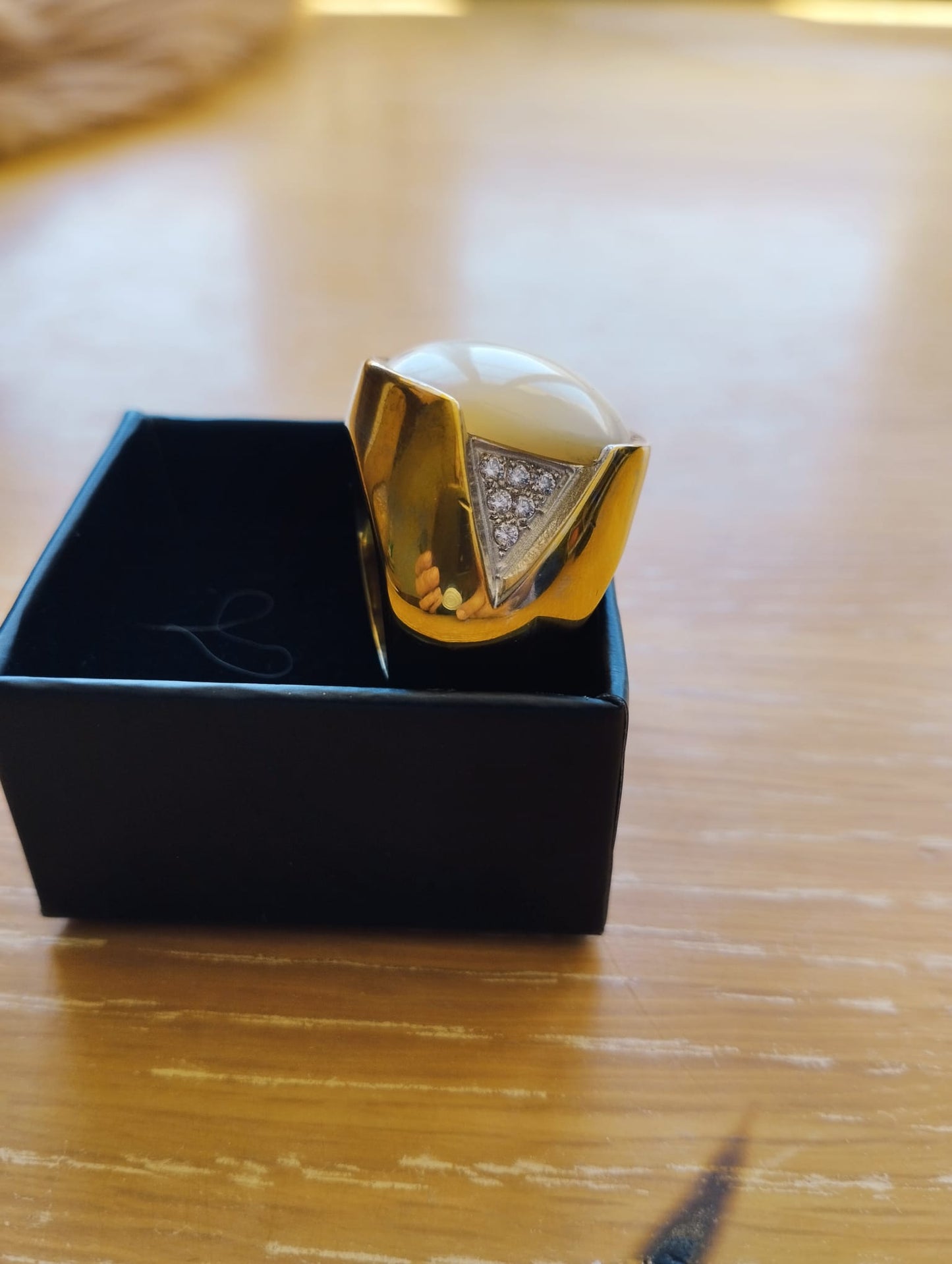 anel madrepérola feminino ELITE dourado com madrepérola central triângulo de zircônias e caixa preta