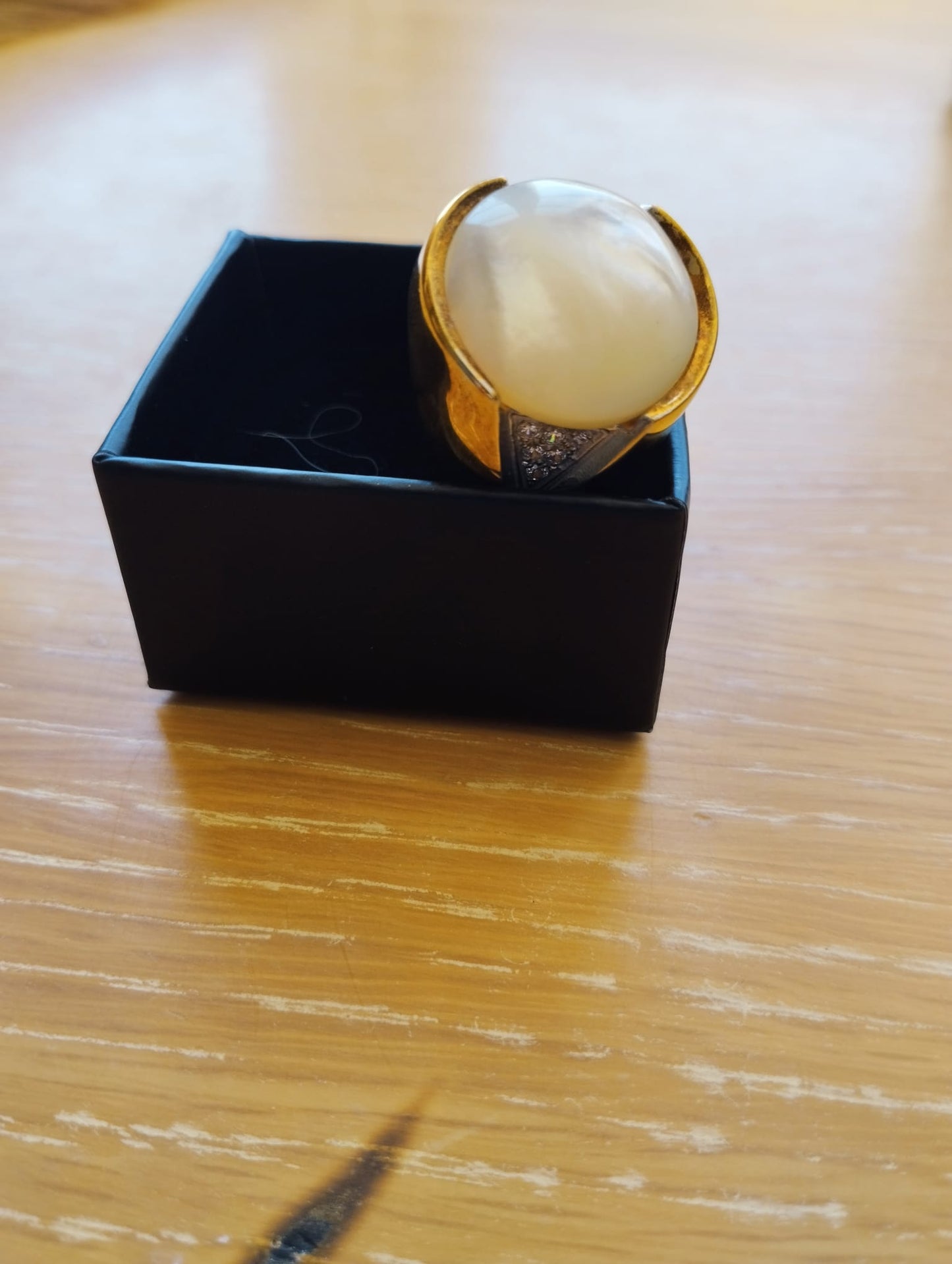 anel madrepérola feminino ELITE em banho dourado com grande cabochão branco, aro largo e laterais com brilho