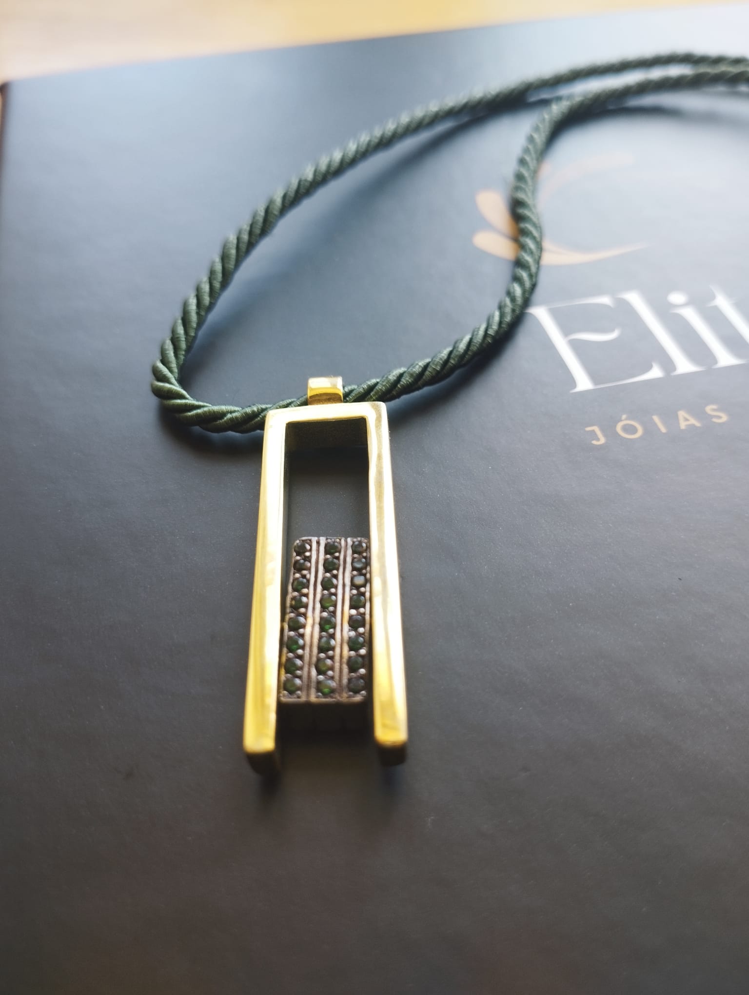 colar dos sorrisos exclusivo ELITE com pingente dourado retangular com barra cravejada de pedras e cordao verde trancado