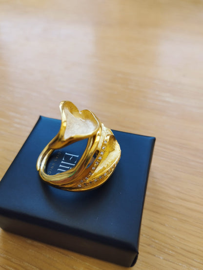 Joia Exclusiva Elite anel de ouro Lirio da Paz anel dourado com design de lirio e pedras sobre caixa preta