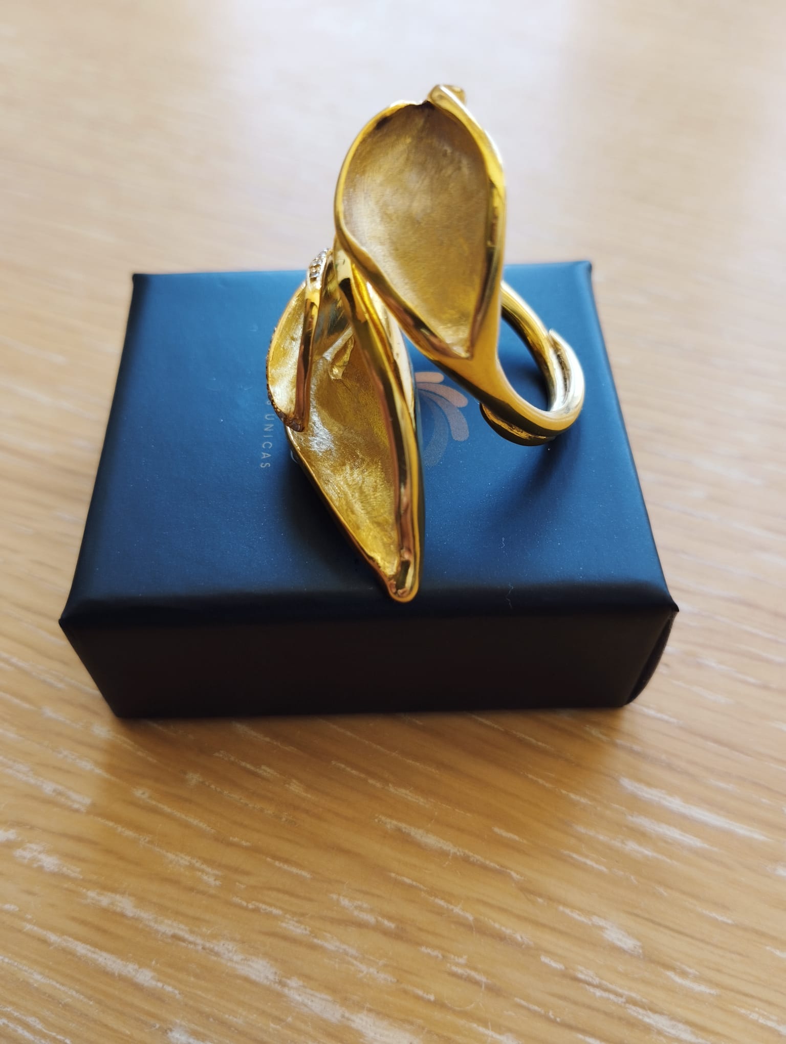 Joia Exclusiva Elite anel de ouro Lirio da Paz. Anel dourado com design floral em forma de lírio sobre caixa preta