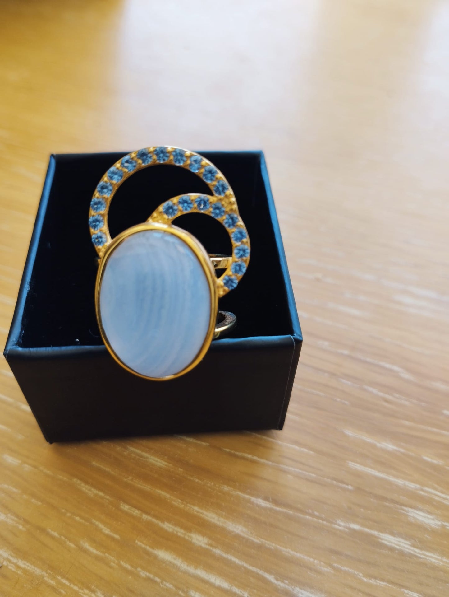 Joia Exclusiva Elite anel de luxo Moon Acquamarina. Anel dourado com pedra oval azul e dois arcos cravejados de pedras azuis