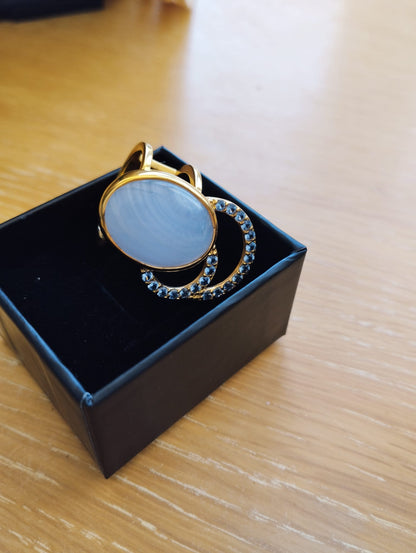 Joia Exclusiva Elite anel de luxo Moon Acquamarina. Anel dourado com pedra oval leitosa e meia lua cravejada em caixa preta