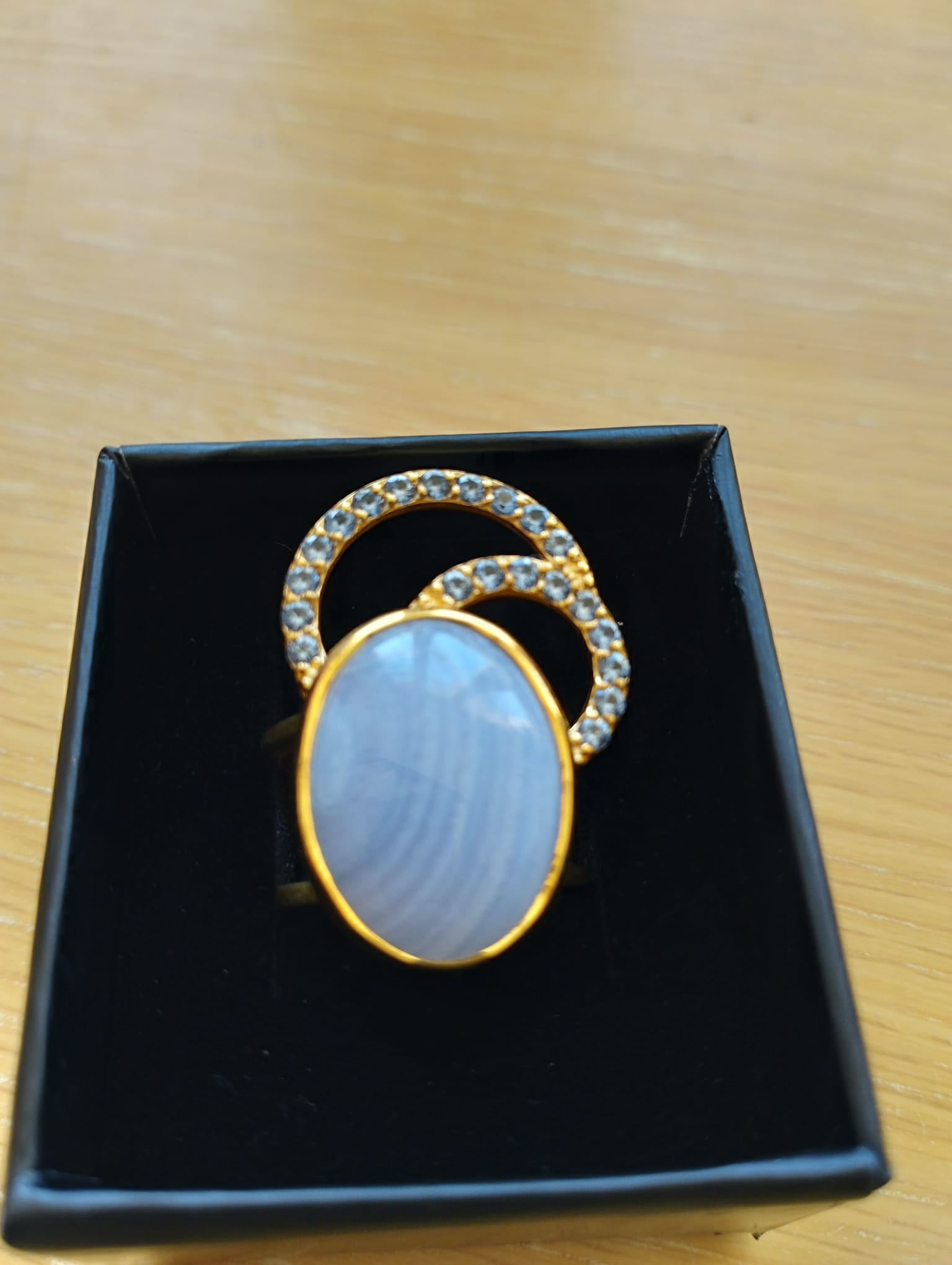 Joia Exclusiva Elite anel de luxo Moon Acquamarina. Anel dourado com pedra oval azul e semicírculos cravejados em caixa preta
